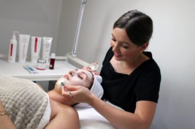 therapist in black shirt performing deep cleansing facial on a woman
