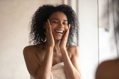 Smiling,African,American,Woman,In,Towel,Touch,Healthy,Glowing,Skin